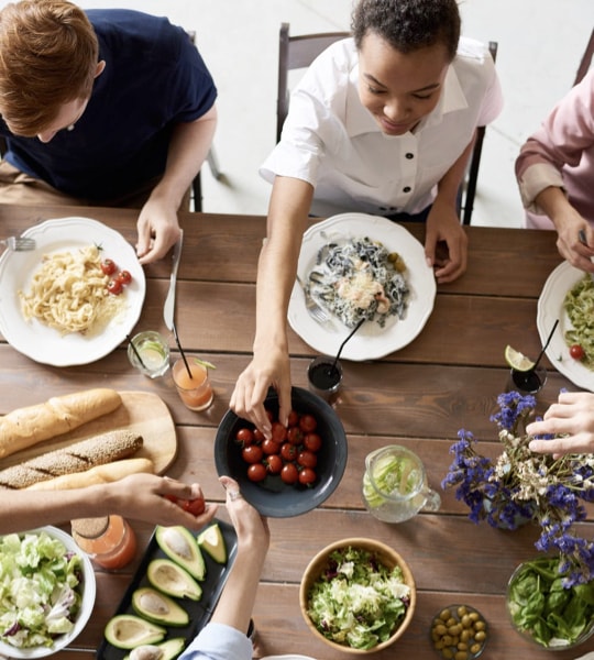 Family members grabbing food from the table